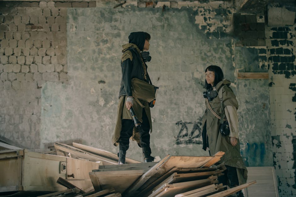 Two people in urban survival gear explore a dystopian, abandoned building setting.